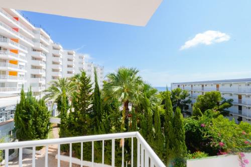 a balcony with palm trees and a building at Apartamentos Vistasol in Magaluf