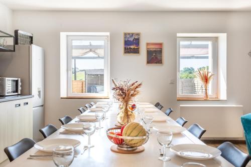 a long table in a room with windows at Gîte Milena - SPA - Puy duFou - Grande capacité in Les Épesses
