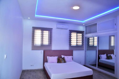 a white room with a bed and a mirror at PalmView - Saly Ngaparou in Saly Portudal