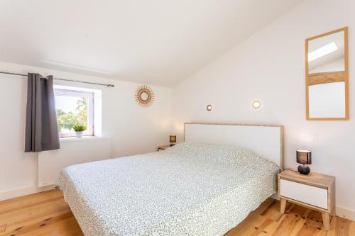 a white bedroom with a bed and a window at Gîte Milena - SPA - Puy duFou - Grande capacité in Les Épesses