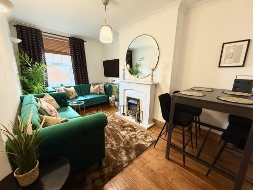a living room with a green couch and a table at Roof Garden @ No.60 High Street in Lyndhurst