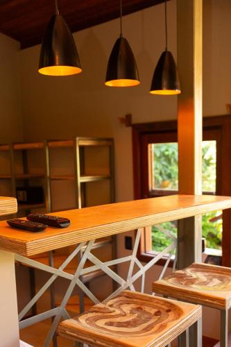 a kitchen with a wooden table and some lights at Pousada Aquarela in Morro de São Paulo
