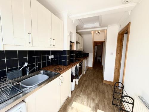 a kitchen with white cabinets and a sink at Roof Garden @ No.60 High Street in Lyndhurst