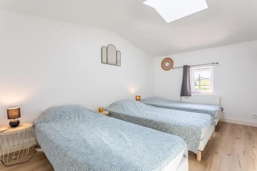 two beds in a white room with blue sheets at Gîte Milena - SPA - Puy duFou - Grande capacité in Les Épesses
