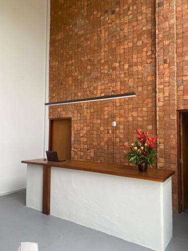 a reception desk in a room with a brick wall at Pousada Sierra in Areia