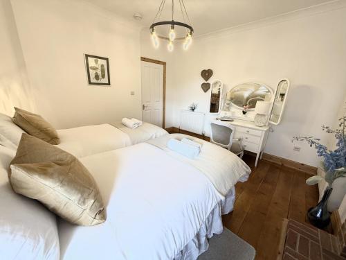 a bedroom with two beds and a desk and a mirror at Roof Garden @ No.60 High Street in Lyndhurst