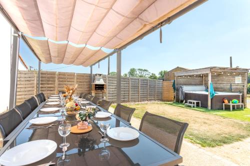 a long dining table in a backyard with a grill at Gîte Milena - SPA - Puy duFou - Grande capacité in Les Épesses