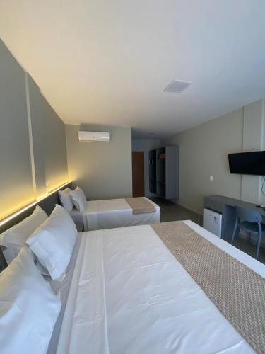 a hotel room with two beds and a desk at Pousada Sierra in Areia