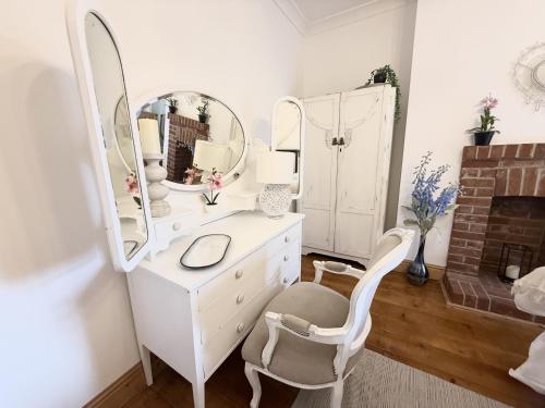 a white dressing table with a mirror and a chair at Roof Garden @ No.60 High Street in Lyndhurst