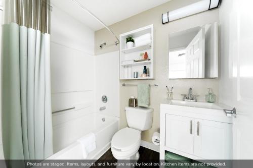 a white bathroom with a toilet and a sink at InTown Suites Extended Stay Newport News VA - South in Newport News