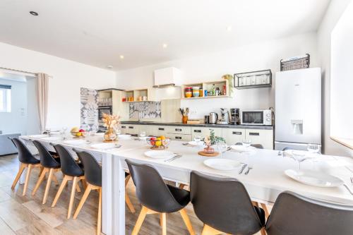 a large dining room with a white table and chairs at Gîte Milena - SPA - Puy duFou - Grande capacité in Les Épesses
