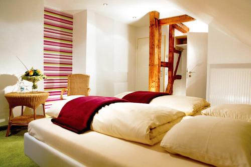 four beds in a room with a table and a window at Flair Hotel Nieder in Bestwig