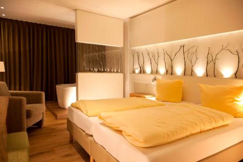 a bedroom with a large white bed with yellow pillows at Flair Hotel Nieder in Bestwig