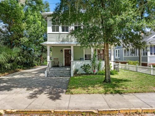 a white house with a tree and a sidewalk at Old City Charm l Historic l Walk to St George in Saint Augustine