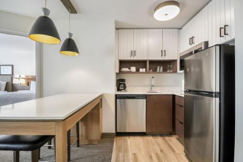 a kitchen with a table and a refrigerator at Staybridge Suites Toledo/Maumee by IHG in Maumee