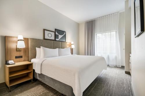 a hotel room with a large bed and a window at Staybridge Suites Toledo/Maumee by IHG in Maumee