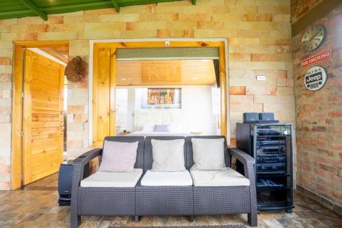 a living room with a couch and a bedroom at Romántica Cabaña con vista a la ciudad, 10 min del Centro in Chiquinquirá