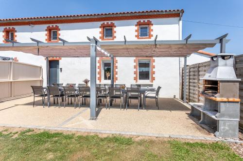 a patio with a table and chairs in front of a building at Gîte Milena - SPA - Puy duFou - Grande capacité in Les Épesses