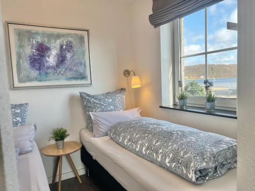 a bedroom with a bed and a window at fewo1846 - Strandresidenz Wassersleben KuestenNest - luxuriöses Studioapartment mit Balkon und Meerblick in Harrislee