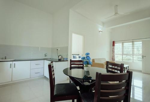 a kitchen and dining room with a table and chairs at Caravan holiday homes Vythiri in Vythiri