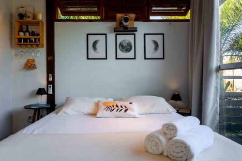 a bedroom with a bed with towels on it at Contêiner 10 Hospedagem in Serra
