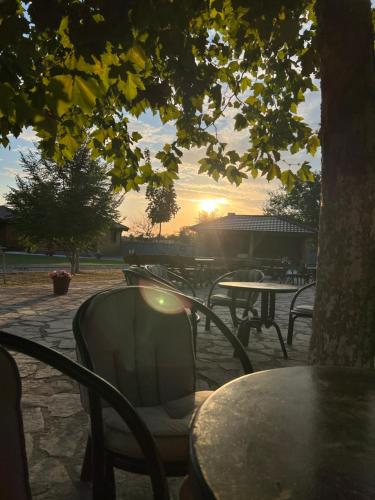 a table and chairs with the sunset in the background at Eko farma Kladovo in Kladovo