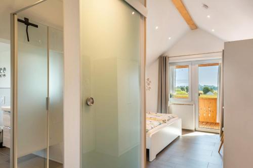 a room with a bed and a glass door at Pur Wohnen - Wohnung Fernsicht in Niederreutern
