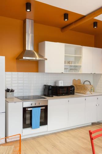 a kitchen with white cabinets and a stove top oven at Chambre privée "verte" - Maison partagée in Amiens