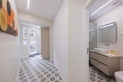 a white bathroom with a sink and a toilet at Modern 2BR Apt with Patio and AC in Lisbon