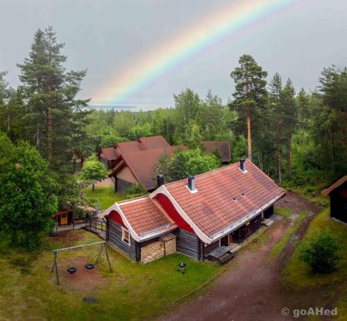 an overhead view of a house with a rainbow in the background at Tomtelandstugan in Mora
