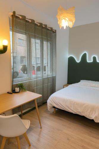 a bedroom with a bed and a table and a desk at Chambre privée "verte" - Maison partagée in Amiens