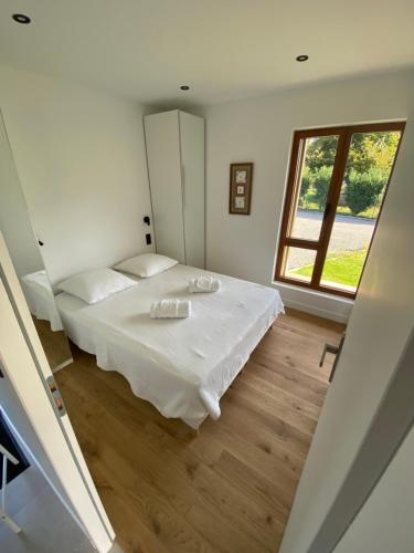 een slaapkamer met een wit bed en een raam bij Chalet Morets in Saint-Gervais-les-Bains