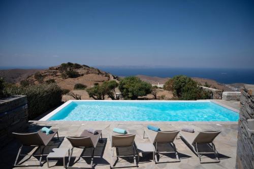 a pool with chairs and a view of the ocean at Melita home in Mesochórion