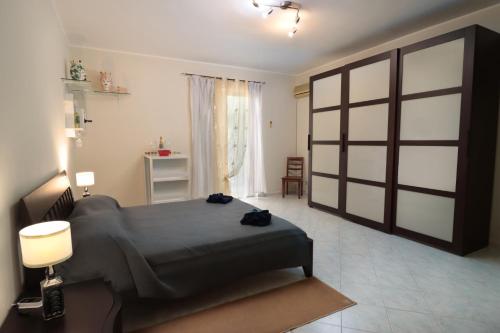 a bedroom with a large bed in a room at Appartamento Le Palme Tra Taormina e Catania in Linera