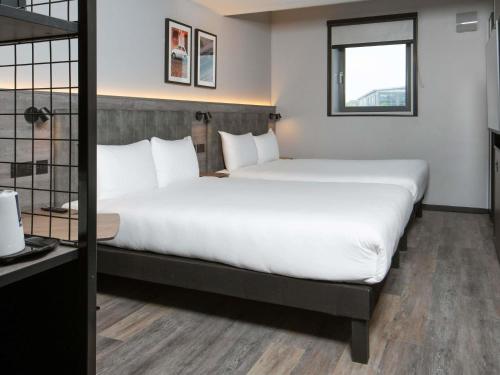 a hotel room with a large bed and a window at ibis Styles London Gatwick Airport in Crawley