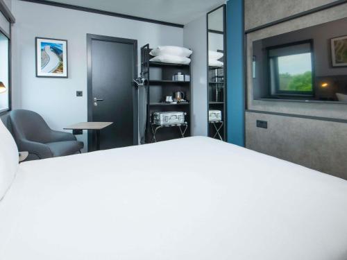 a room with a bed and a table and a window at ibis Styles London Gatwick Airport in Crawley