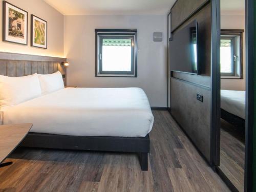 a hotel room with a bed and a tv at ibis Styles London Gatwick Airport in Crawley