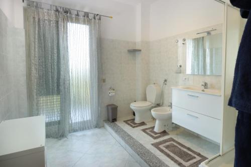 a bathroom with a toilet and a sink and a shower at Appartamento Le Palme Tra Taormina e Catania in Linera
