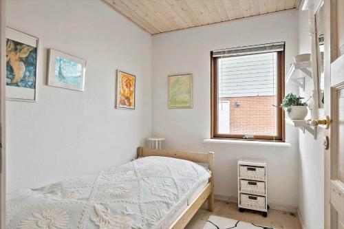 un dormitorio con una cama y una ventana en 70794-Ulfborg-Skolegade-17, en Thorsminde