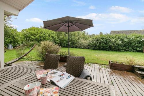 a wooden table with an umbrella on a deck at K19045-Kalundborg-Lobelievej-3 in Kalundborg