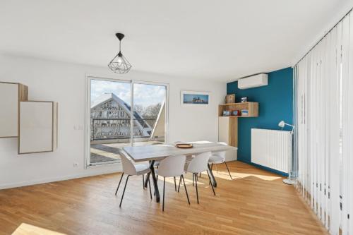 a dining room with a white table and chairs at spacious and bright apartment in Bordeaux