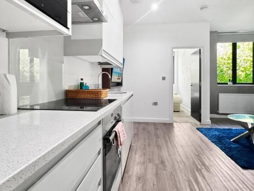 a kitchen with white cabinets and a blue rug at Clyde Inn in Milton Keynes