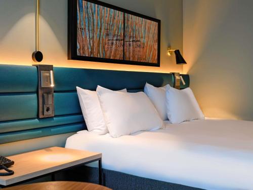 a hotel room with two beds with white pillows at Novotel Luxembourg Kirchberg in Luxembourg