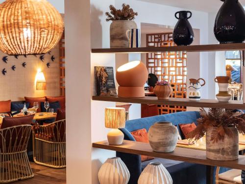 a room filled with shelves filled with vases at Novotel Luxembourg Kirchberg in Luxembourg
