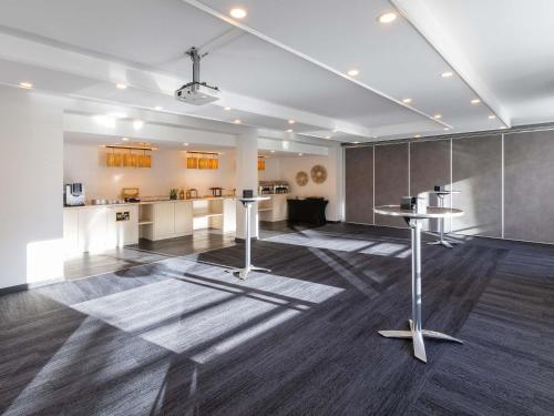 a large room with a kitchen and a living room at Novotel Luxembourg Kirchberg in Luxembourg