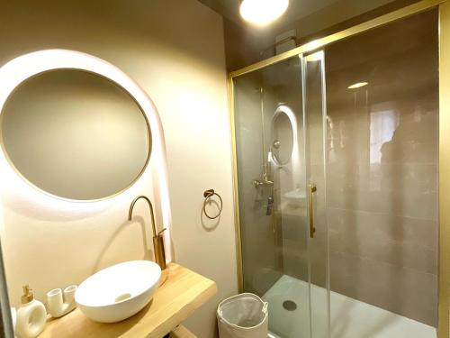 a bathroom with a sink and a shower with a mirror at Les 1001 nuits in Albi