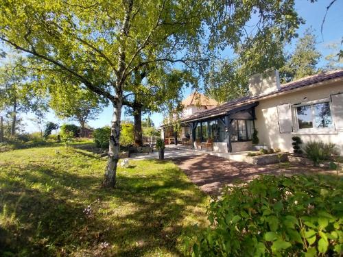 a house with a tree in the yard at La Chesnaie in Bonnes