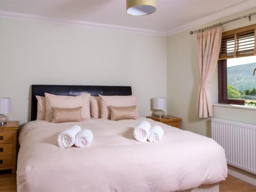 a bedroom with a white bed with towels on it at 4 Bed in Ystradgynlais BN343 in Ystalyfera