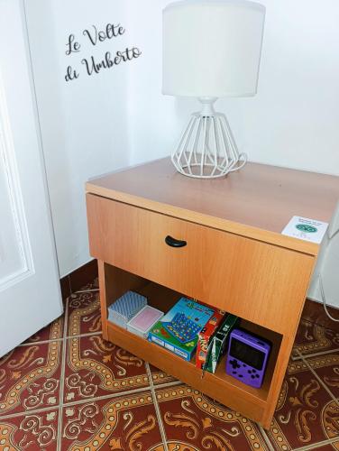 a wooden table with a lamp on top of it at Le volte di Umberto: camera e rilassante terrazzo in Sogliano Cavour