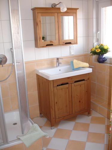 a bathroom with a sink and a shower at Pension Lüttje Meermaid in Borkum
